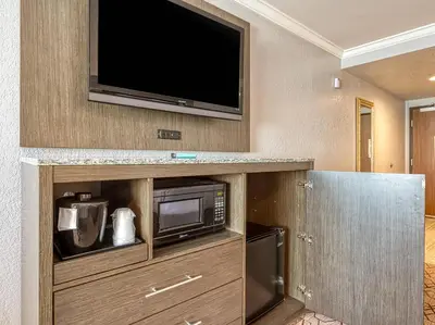 a room with a microwave and a television on a wall at Amanzi Hotel, an Ascend Collection Hotel in Ventura