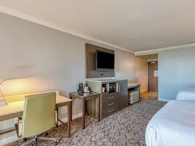 a hotel room with a bed and a desk with a computer at Amanzi Hotel, an Ascend Collection Hotel in Ventura