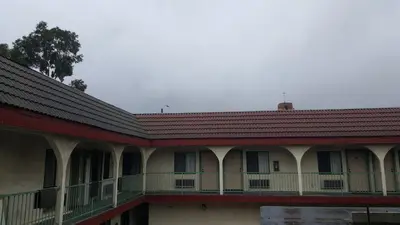an old building with a red roof and a balcony at Flamingo Inn Long Beach in Long Beach