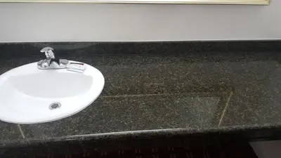 a white sink on a black counter in a bathroom at Flamingo Inn Long Beach in Long Beach