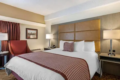 a hotel room with a large bed and a chair at Best Western Plus Thousand Oaks Inn in Thousand Oaks