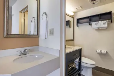 a bathroom with a sink and a toilet and a mirror at Best Western Plus Thousand Oaks Inn in Thousand Oaks