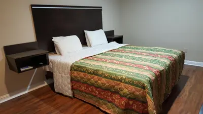 a bedroom with a bed with a blanket and a night stand at ACE Motel in Pasadena