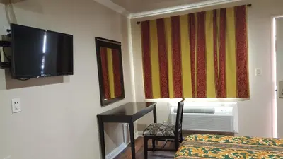 a room with a bed and a television on the wall at ACE Motel in Pasadena