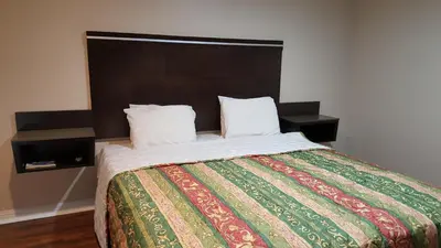 a bedroom with a large bed with a colorful blanket at ACE Motel in Pasadena