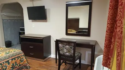 a bedroom with a bed and a desk and a mirror at ACE Motel in Pasadena