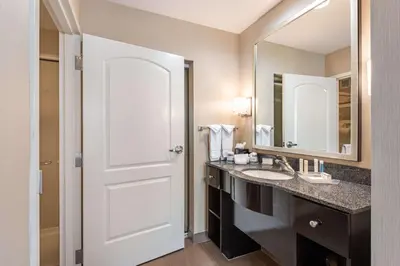 a bathroom with a white door and a sink at Homewood Suites by Hilton Oxnard/Camarillo in Oxnard