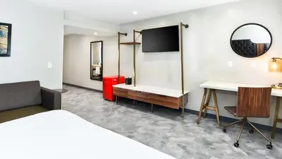 a hotel room with a bed and a desk at Hollywood Inn Suites Hotel in Los Angeles