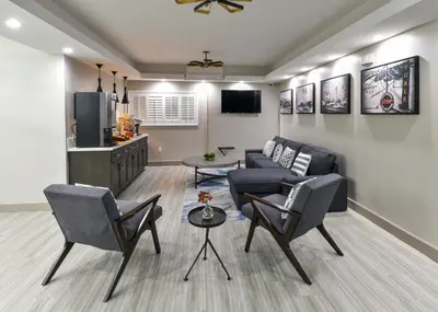a living room with a couch and chairs and a tv at Hollywood Inn Suites Hotel in Los Angeles