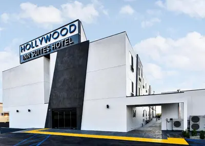a white building with a sign on it at Hollywood Inn Suites Hotel in Los Angeles