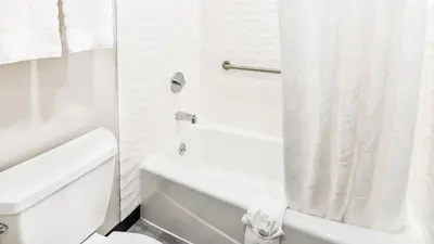 a white bathroom with a toilet and a shower at Hollywood Inn Suites Hotel in Los Angeles