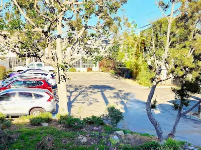 a row of cars parked in a parking lot at Santa Paula Inn in Santa Paula