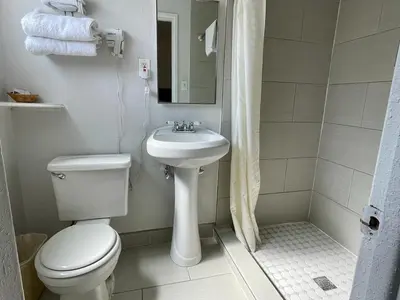 a white bathroom with a toilet and a sink at Desert Inn in Mojave