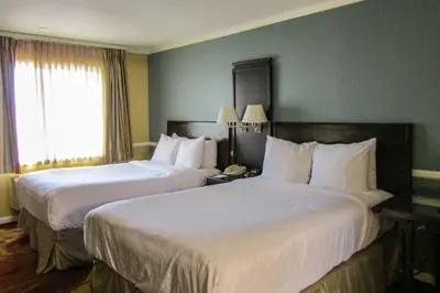 a hotel room with two beds and a window at Clarion Inn Near China Lake Naval Station in Ridgecrest
