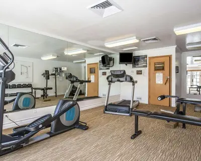 a gym with treadmills and ellipticals in a room at Clarion Inn Near China Lake Naval Station in Ridgecrest