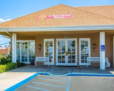a convenience store with two benches in front of it at Clarion Inn Near China Lake Naval Station in Ridgecrest