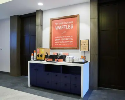 a counter in a lobby with a sign on the wall at Hampton Inn & Suites Sherman Oaks in Sherman Oaks