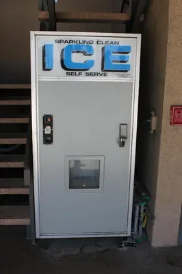 a white gas pump with a sign on it at Orange Tustin Inn in Orange in Orange
