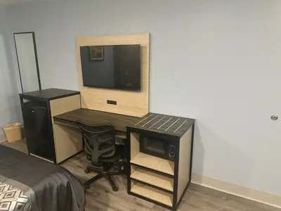 a bedroom with a desk with a tv and a chair at Orange Tustin Inn in Orange in Orange