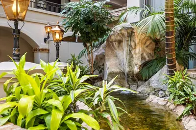 a garden with a waterfall and a palm tree at Embassy Suites by Hilton Los Angeles International Airport South in El Segundo