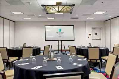 a conference room with tables and chairs and a screen at Embassy Suites by Hilton Los Angeles International Airport South in El Segundo