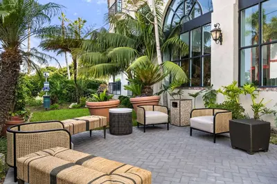 a patio with chairs and tables in front of a building at Embassy Suites by Hilton Los Angeles International Airport South in El Segundo