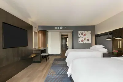 a hotel room with two beds and a flat screen tv at Embassy Suites by Hilton Los Angeles Downey in Downey