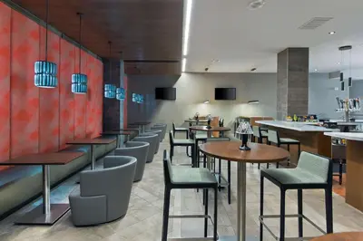 a restaurant with tables and chairs and a bar at Embassy Suites by Hilton Los Angeles Downey in Downey