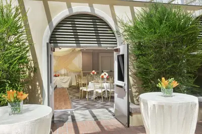 a patio with a table and chairs and an open door at Embassy Suites by Hilton Los Angeles Downey in Downey