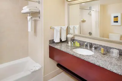 a bathroom with a sink and a tub and a mirror at DoubleTree by Hilton Los Angeles/Commerce in Commerce