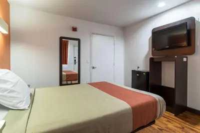 a hotel room with a bed and a flat screen tv at Motel 6 Riverside, CA - UCR East in Riverside