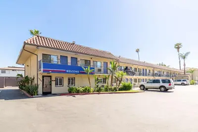 a building with a car parked in a parking lot at Motel 6 Riverside, CA - UCR East in Riverside