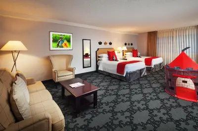 a hotel room with two beds and a couch at Anaheim Majestic Garden Hotel in Anaheim