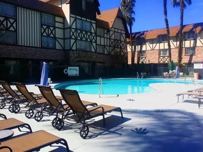 a group of chairs sitting around a swimming pool at Anaheim Majestic Garden Hotel in Anaheim