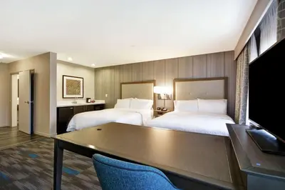 a hotel room with two beds and a table at Hampton Inn & Suites Los Angeles Burbank Airport in Burbank