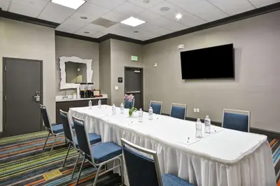 a conference room with a table and chairs and a flat screen tv at Hampton Inn & Suites Los Angeles Burbank Airport in Burbank