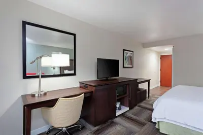 a hotel room with a desk with a bed and a television at Hampton Inn Los Angeles/Arcadia in Arcadia