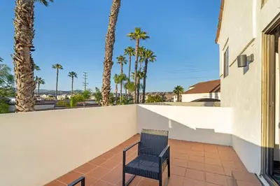 a chair sitting on a balcony with palm trees at Best Western Posada Royale Hotel & Suites in Simi Valley