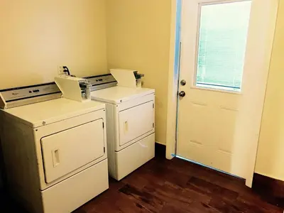 a laundry room with two washes and a window at Days Inn by Wyndham Anaheim Near the Park in Anaheim