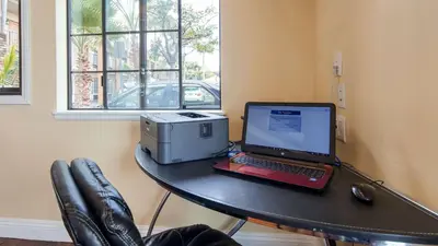 a table with a laptop computer and a printer on it at Best Western Palm Garden Inn in Westminster