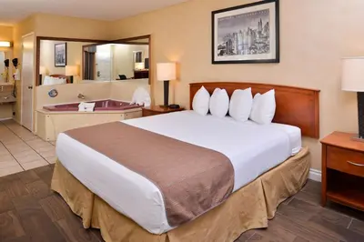 a hotel room with a large bed and a bathroom at Best Western Palm Garden Inn in Westminster
