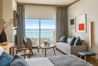 a living room with a couch and a view of the ocean at Malibu Beach Inn in Malibu