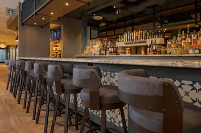 a bar with a row of stools in a restaurant at Knott's Hotel in Buena Park