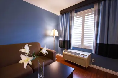 a living room with a couch and a table with flowers at Regency Inn in Los Angeles in Los Angeles