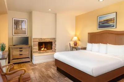 a hotel room with a bed and a fireplace at Clocktower Inn Ventura in Ventura