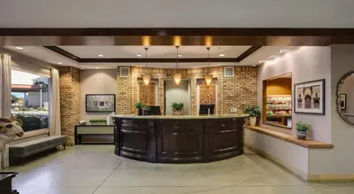 a large lobby with a bar in a building at Ayres Hotel Chino Hills Ontario in Chino Hills