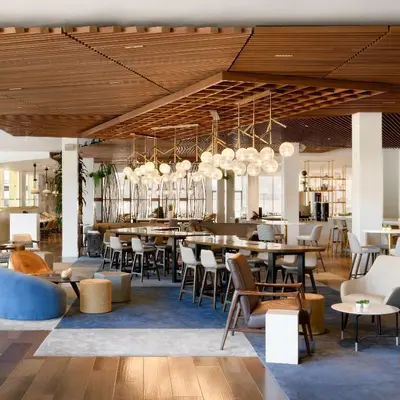 a restaurant with wooden ceilings and tables and chairs at Hilton Los Angeles-Culver City, CA in Los Angeles