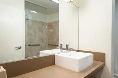 a bathroom with a white sink and a mirror at Maywood Inn in Maywood