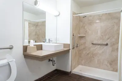 a bathroom with a sink and a shower at Maywood Inn in Maywood