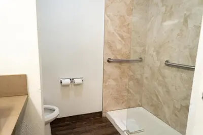 a bathroom with a shower with a toilet at Maywood Inn in Maywood